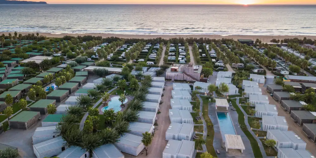 Vista aèria d'un càmping familiar davant del mar a la Costa Brava amb piscina i accés directe a la platja