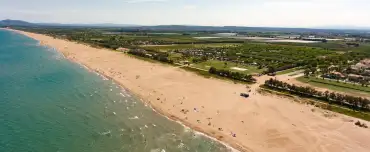 Vista aèria d'un càmping familiar davant del mar a la Costa Brava amb piscina i accés directe a la platja