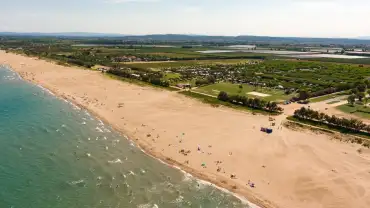 Vista aèria d'un càmping familiar davant del mar a la Costa Brava amb piscina i accés directe a la platja